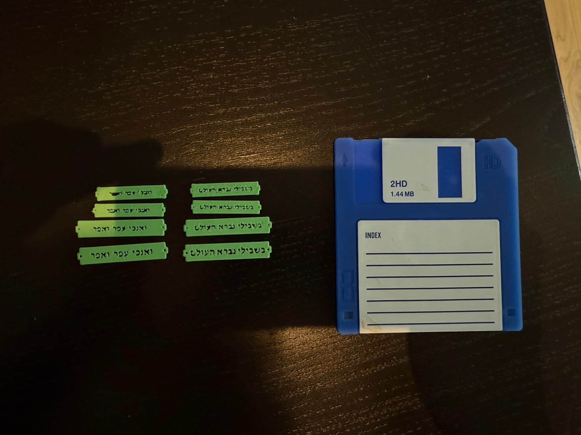 A number of 3D-printed test models next to a floppy disk.